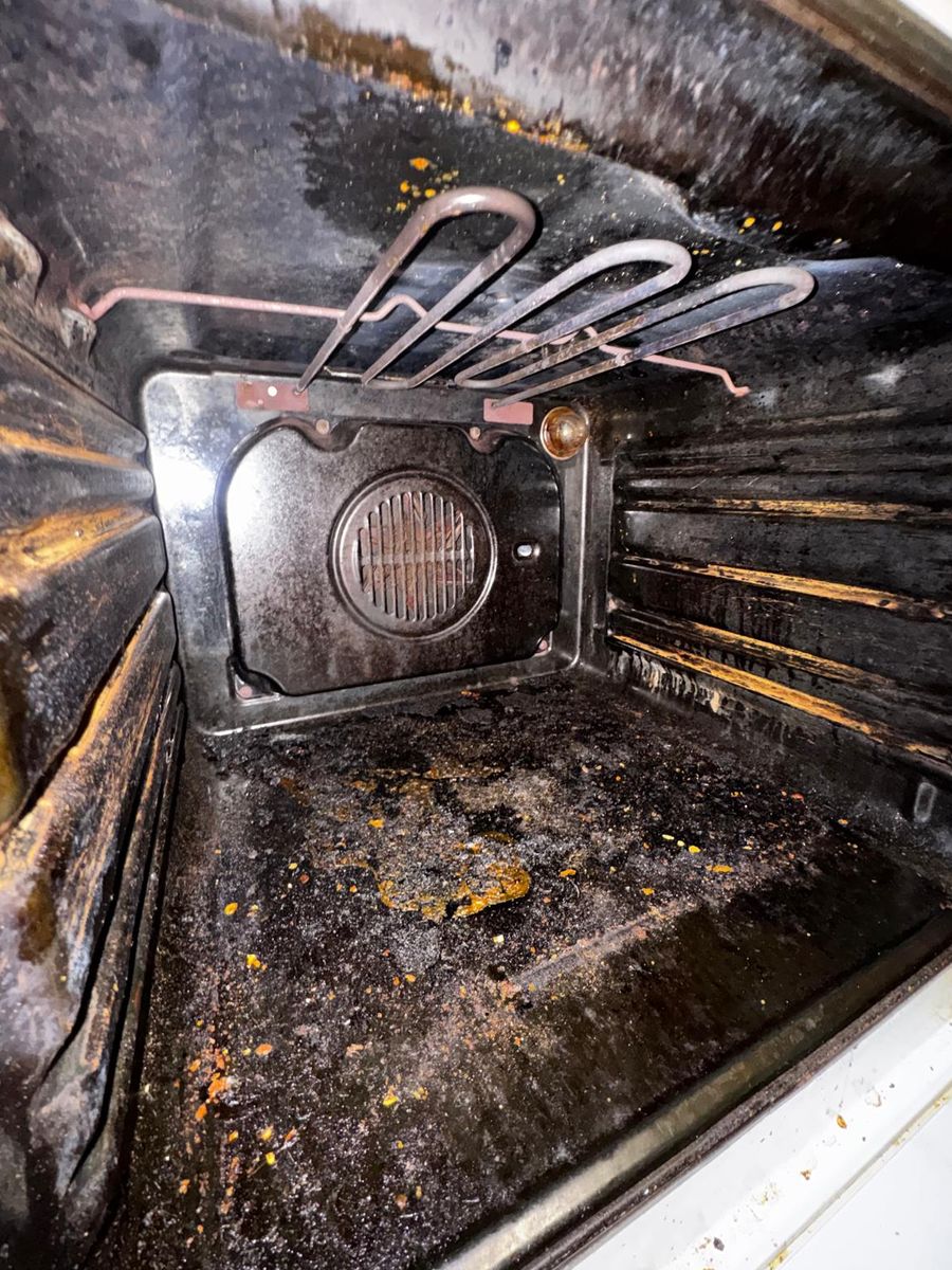 The same oven before cleaning: burnt-on grease inside
